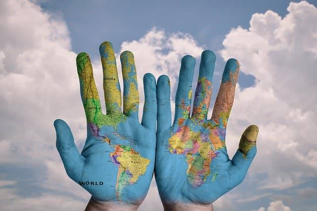 Hands painted with a world map used as preview for Human and Natural Geography